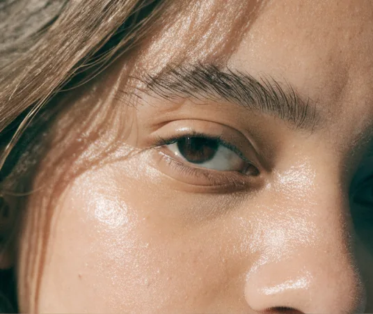 Close do rosto de uma mulher com a pele iluminada